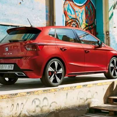 Red car parked in front of a colourful graffiti wall