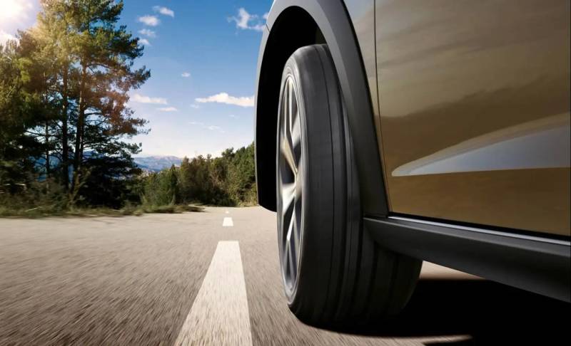 Close-up of a car tire driving on an open road