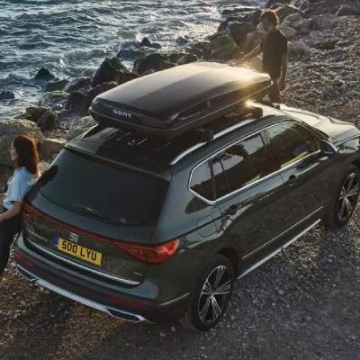 SUV with a roof box parked by the seaside